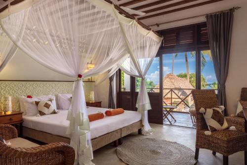 1 dormitorio con 1 cama con cortinas blancas en Zanzibar Magic Boutique Hotel, en Matemwe
