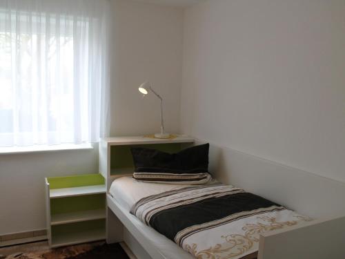 ボルテンハーゲンにあるModern Apartment near Sea in Ostseebad Boltenhagenの小さなベッドルーム(ランプ付きのベッド付)