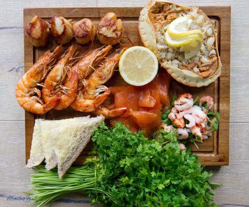 a plate of food with shrimp and other foods at Hythe Imperial Hotel, Spa & Golf in Hythe