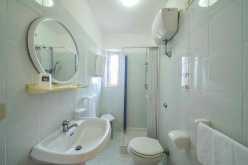 La salle de bains est pourvue d'un lavabo, de toilettes et d'un miroir. dans l'établissement Hotel Piccolo Paradiso, à Peschici