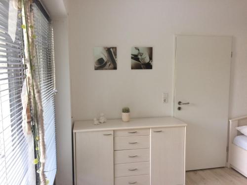 ein Schlafzimmer mit einer Kommode und zwei Bildern an der Wand in der Unterkunft FeWo direkt am Lift in Winterberg