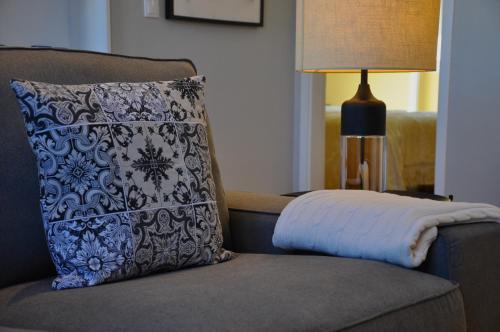 a pillow sitting on a couch next to a lamp at Confluentia H&A - Believe It or Not Apartments in Coimbra