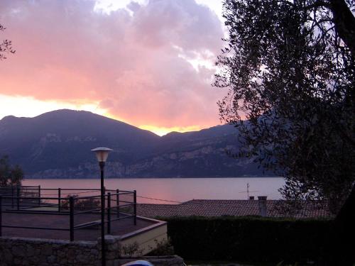 een uitzicht op een meer met een zonsondergang op de achtergrond bij Aquacamp in Brenzone sul Garda