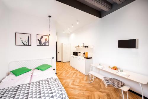 a white bedroom with a bed and a desk at Art Apartments Rynok Square in Lviv
