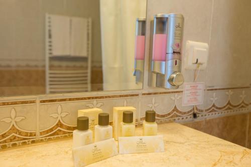 een groep van vier flessen lotion op een aanrecht in een badkamer bij Marina Grand Beach Hotel - All Inclusive Plus in Goudstrand