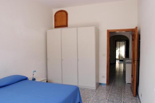 a bedroom with a blue bed and a large white cabinet at Residence Le Villette in Ravello