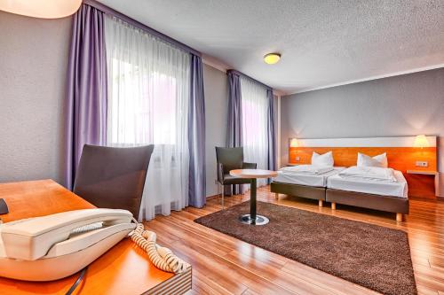 Giường trong phòng chung tại attimo Hotel Stuttgart***S