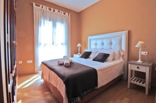 sypialnia z dużym łóżkiem i oknem w obiekcie Del Parque Flats - Cervantes w Maladze