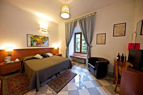 ローマにあるHotel Carmelのベッドとテレビが備わるホテルルームです。
