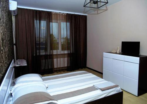 ヴォロネジにあるATLANT Apartments 111のベッドルーム1室(ベッド1台、大きな窓付)