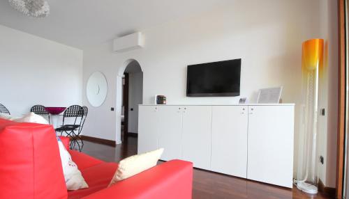 ミラノにあるItalianway-Rucellaiのリビングルーム(赤いソファ、白いキャビネットのテレビ付)