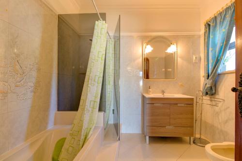 a bathroom with a shower and a sink and a tub at Villas2go2 V5 Vilamoura XXI in Vilamoura