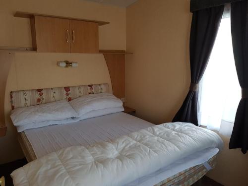 um quarto com uma cama e uma janela em 6 Berth with Sea Views on Beachside em Brean