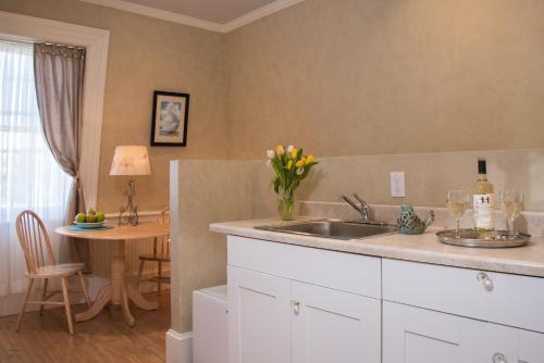 a kitchen with a sink and a table with wine glasses at Captain Farris House in South Yarmouth