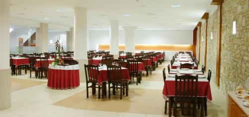 a dining room with red tables and chairs at Hotel Recinto in Fátima