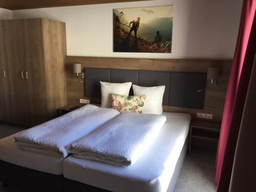ein Schlafzimmer mit einem großen Bett mit blauer Bettwäsche in der Unterkunft Nonas B&B in Galtür