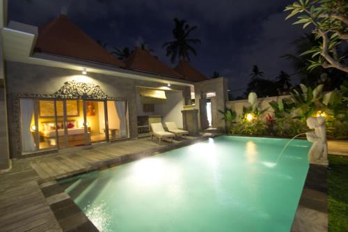 a pool in the backyard of a villa at night at Ubud Lestari Villa in Ubud