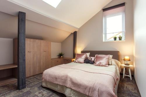 a bedroom with a large bed with a window at Old Town Trio Apartments in Vilnius