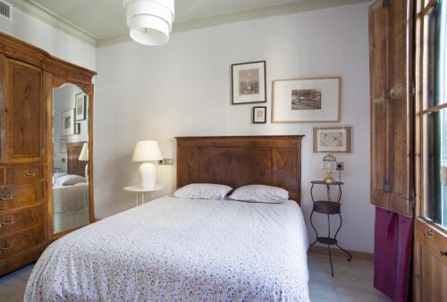 een slaapkamer met een groot bed met een houten hoofdeinde bij ApartEasy - Authentic Family Apartment in Barcelona