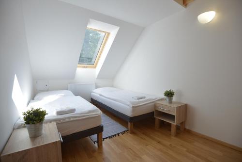 a small room with two beds and a window at Restaurace a Pension Hřebíkárna in Chomutov