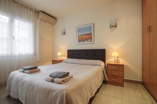 バルセロナにあるApartEasy - Family Apartment Sant Antoniのベッドルーム1室(ベッド1台、タオル2枚付)