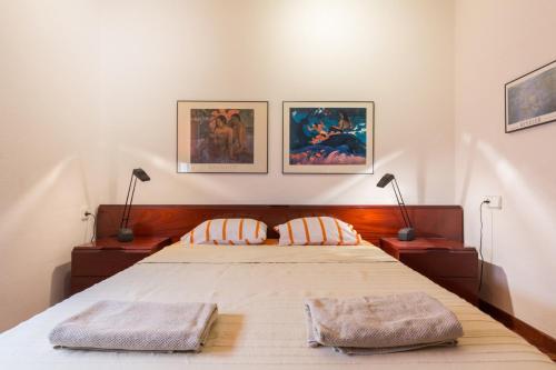 a bedroom with a large bed with two pillows at ApartEasy - Port Barcelona in Barcelona