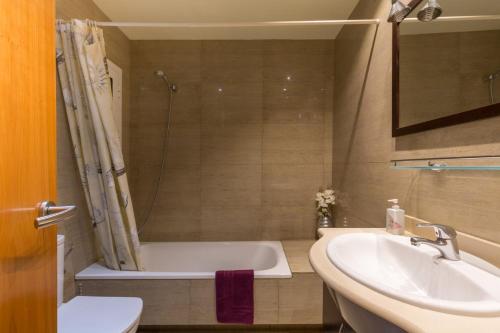 een badkamer met een bad en een wastafel bij ApartEasy - Family Apartment Sant Antoni in Barcelona
