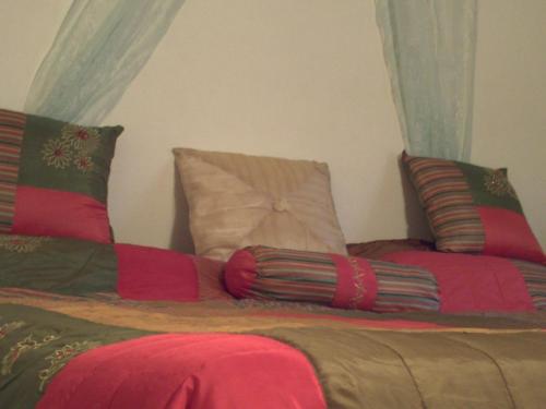 a bed with red and green sheets and pillows at LeMarida Suites in Saint Peter