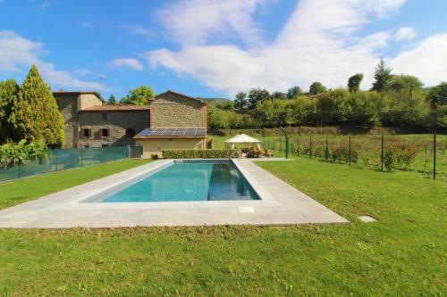 a swimming pool in a yard next to a house at Antico Mulino in Palazzo del Pero