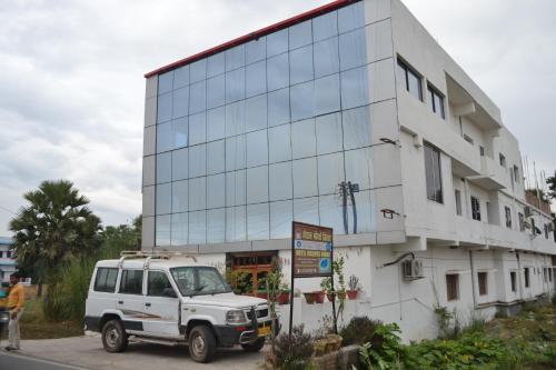 un camion blanc garé devant un bâtiment dans l'établissement Hotel Maurya Vihar Bodhgaya, à Bodh Gaya