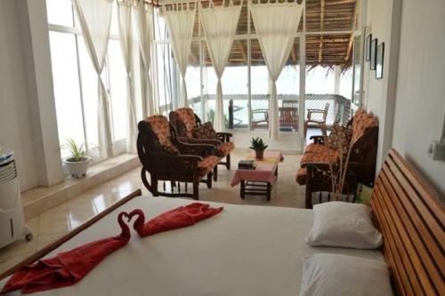 a bedroom with a bed with two red towels on it at Happy Tuna Beach Apartment in Hikkaduwa