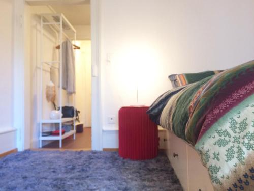 een slaapkamer met een bed en een rode tafel bij In Swiss Home - Rathaus from 1284 historical Apartment in Bazel