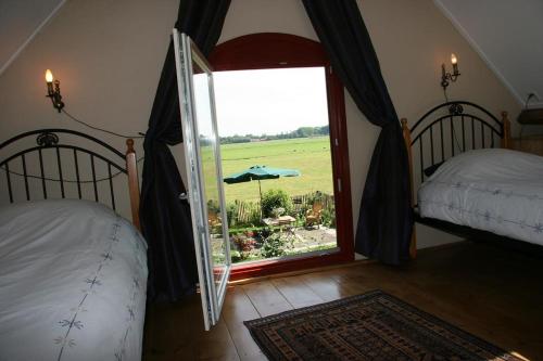 een slaapkamer met 2 bedden en een raam met uitzicht bij De Lage polder in Linschoten