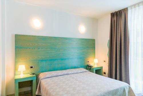 
a hotel room with a bed and two lamps at Hotel Montecristo in Marina di Campo
