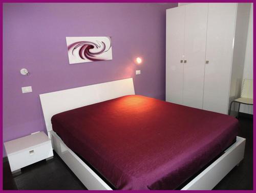サン・ヴィート・ロ・カーポにあるNuovissima casa Vacanze a San Vito Lo Capoの紫の壁のベッドルーム1室