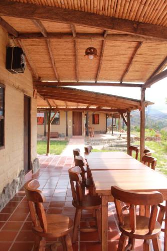einen Holztisch und Stühle auf einer Terrasse in der Unterkunft Posada El Artesano De Raquira in Ráquira