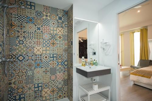 un bagno con lavandino e doccia di Algo Diferente Apartamentos a Cordoba