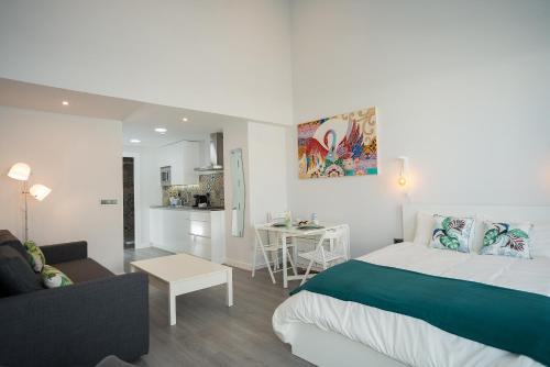 コルドバにあるAlgo Diferente Apartamentosのベッドルーム1室(ベッド1台付)、リビングルームが備わります。
