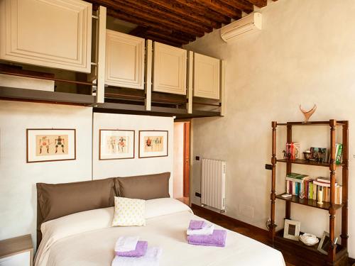 een slaapkamer met een bed en een boekenplank bij WP RELAIS Biennale in Venetië