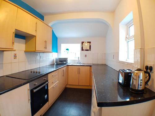 a large kitchen with a black counter top at Jefferson House in Goole