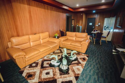a living room with two couches and a table at Butuan Grand Palace Hotel in Butuan