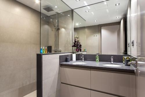 a bathroom with two sinks and a large mirror at Elegant Eixample Apartment nicely decorated in Barcelona