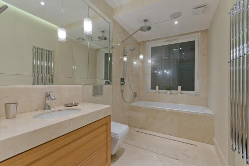 a bathroom with a sink and a tub and a toilet at Apartament Molo Superior in Sopot