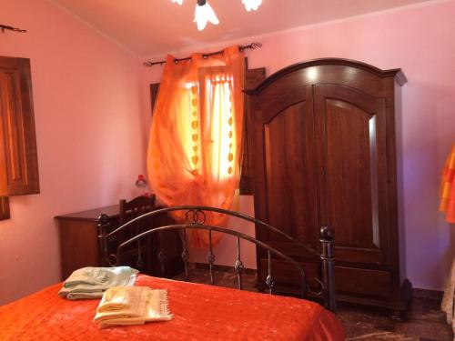1 dormitorio con 1 cama y armario de madera en Sa Perda Lada, en Fluminimaggiore