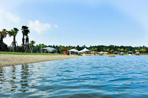 a body of water with houses and palm trees at FLAMINGOS Villa Happy 3 phòng ngủ- view Hồ- bể bơi riêng in Ngọc Quang