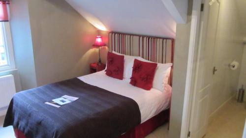 a bedroom with a large bed with red pillows at Monties Guest House - Adults ONLY in Bowness-on-Windermere
