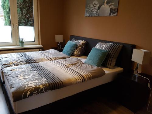 ein Schlafzimmer mit einem Bett mit blauen Kissen in der Unterkunft Emderhaus in Emden