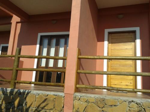 una casa con una valla y dos ventanas en Chale Por do Sol, en Ilhabela