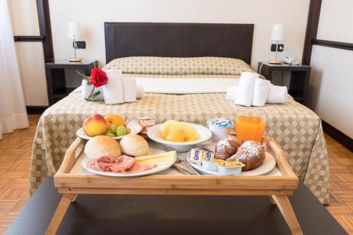 a tray of food on top of a bed at Hotel Astoria in Fidenza