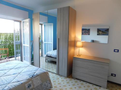 een slaapkamer met een bed en een spiegel bij Casa Azzurra in Riva Ligure